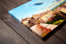 Canvas Photo Print On Brown Wooden Background. Side View Of Colorful Photography With Gallery Wrap. Photo Printed On Glossy Canvas Closeup
