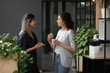 © fizkes - Businesswomen discuss project standing in workplace hall during coffee break