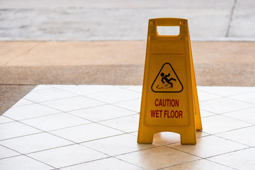 warning beware accident concept, The image of yellow caution wet floor plastic sign put on the concrete floor.