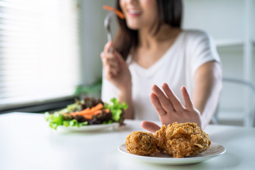 woman on dieting for good health concept, young women use hands to push fried chicken and choose to 