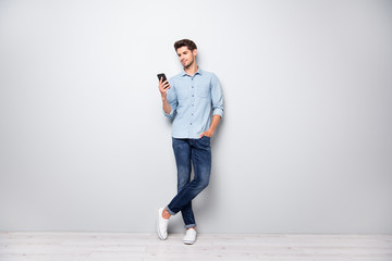 Poster - Full size photo of concentrated smm worker man use cellphone answer sms messages have online conversation with friends type comments posts wear stylish outfit sneakers isolated grey color background
