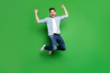 Full length body size photo of cheerful crazy ecstatic guy rejoicing with his favorite sport team having won competitions isolated jumping isolated over green vivid color background