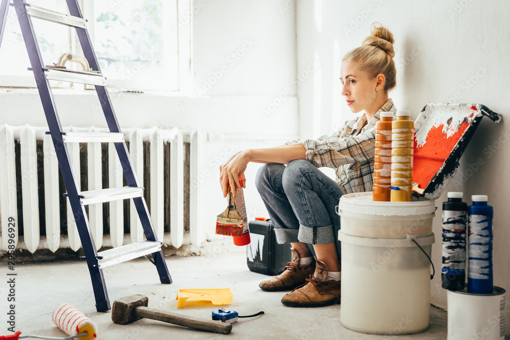 Pretty young woman makes DIY repairs in the house with her own hands. Concept nontraditional gender roles, gender equality, the image of femininity