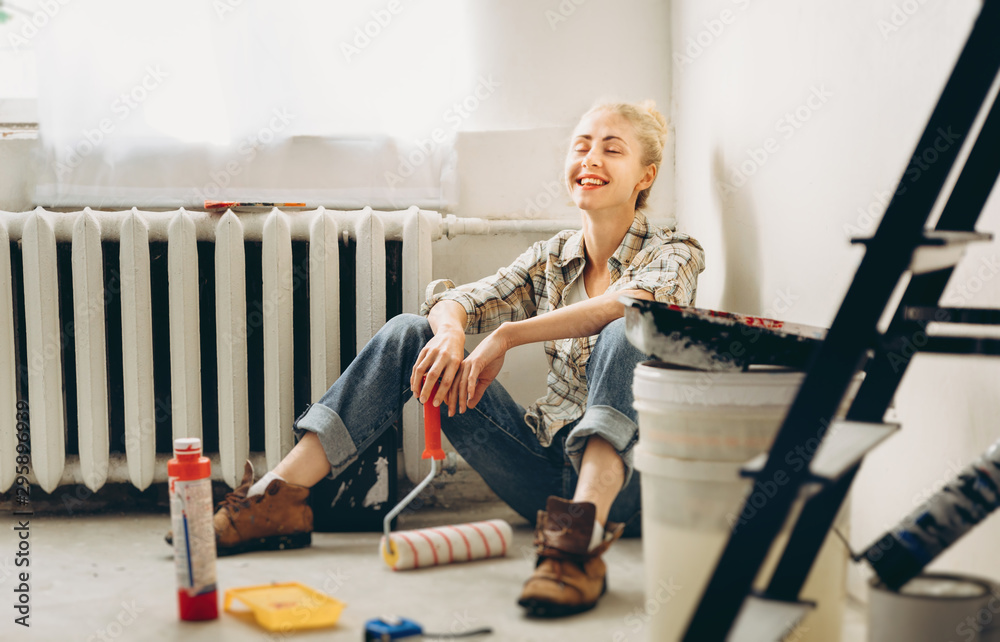 Happy Pretty young woman makes DIY repairs in the house with her own hands. Concept nontraditional gender roles, gender equality, the image of femininity