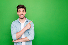 Photo Of Amazing Salesman Guy In Excited Mood Indicating Finger To Empty Space Advising Cool Shopping Prices Wear Casual Denim Shirt Isolated Green Color Background
