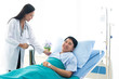 © Toefotostock - The doctor is the pressure gauge. The patient is lying in a hospital bed.female doctor with happy patient at the hospital.