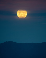full moon rising over the mountains