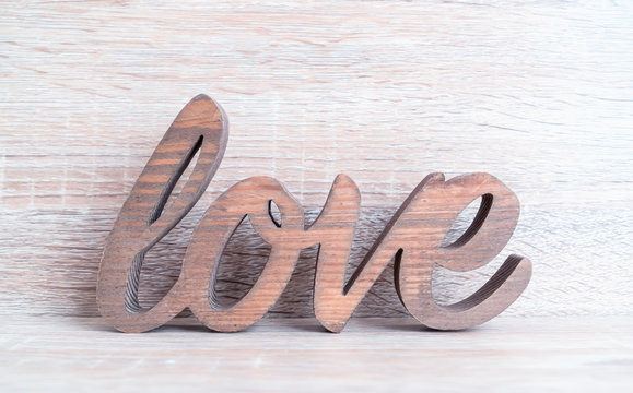Wooden letters forming word LOVE written on wooden background