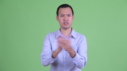 Poster - Studio shot of happy Asian businessman clapping hands