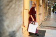 © Anton - Beautiful stylish blond girl in knitted sweater with bags happily leaving store after shopping