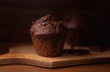 Close-up at the chocolate muffins on a wooden chopping board, dark moody food photography