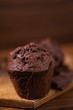 Chocolate muffins on a wooden chopping board, dark moody food photography
