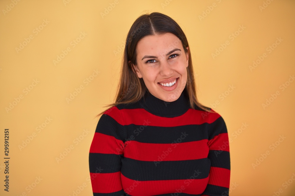 Young beautiful woman smiling happy wearing a sweater over isolated yellow background