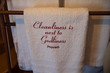 White towel with Cleanliness is next to Godliness proverb embroidered on it