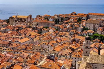 Bell tower with old stone houses with red roofs in old historic Dubrovnik city, Dalmatia, Croatia, blue summer day, the most popular touristic destination