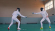 © KONSTANTIN SHISHKIN - Two young fencers are training in the gym