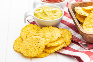 Wall Mural - Round nacho chips and avocado dip. Yellow tortilla chips and guacamole in bowl.