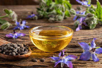 Wall Mural - A bowl of borage oil and borage seeds and flowers