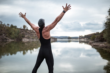 swimmer in swimsuit glasses and cap in open water