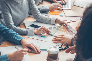 Designers working together at office having business meeting table close-up looking at palette