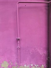 Purple Tube. Purple Pipe On A Purple Background. Pipe Bend. Background Of Old Plaster.