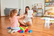 © Krakenimages.com - Beautiful psycologist and blond toddler girl sitting on the floor doing therapy using emoji emotions at consulting room