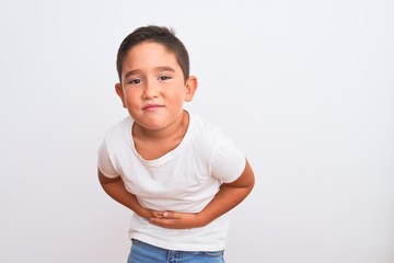 Poster - Beautiful kid boy wearing casual t-shirt standing over isolated white background with hand on stomach because nausea, painful disease feeling unwell. Ache concept.