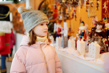 Young Girl Looking At Christmas Dolls And Decorations Sold At Christmas Market In Vilnius, Lithuania.