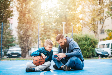 Wall Mural - Father and his son enjoying together on basketball court.