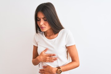 Wall Mural - Young beautiful woman wearing casual t-shirt standing over isolated white background with hand on stomach because indigestion, painful illness feeling unwell. Ache concept.