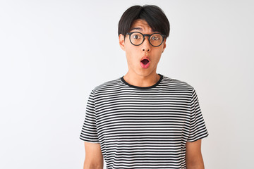 Wall Mural - Chinese man wearing glasses and navy striped t-shirt standing over isolated white background afraid and shocked with surprise expression, fear and excited face.