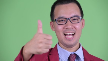 Wall Mural - Face of happy Asian businessman with eyeglasses giving thumbs up
