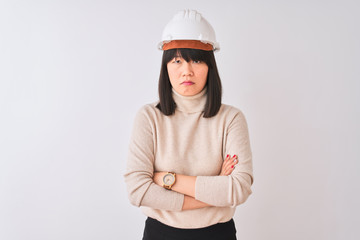 Wall Mural - Young beautiful Chinese architect woman wearing helmet over isolated white background skeptic and nervous, disapproving expression on face with crossed arms. Negative person.