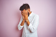 © Krakenimages.com - Young indian businessman wearing elegant shirt standing over isolated pink background with sad expression covering face with hands while crying. Depression concept.