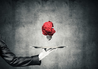 Wall Mural - Hand of waiter presenting crampled paper lightbulb