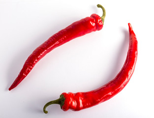 two red chili peppers on a white background