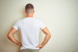 © Krakenimages.com - Young handsome man wearing casual white t-shirt over isolated background standing backwards looking away with arms on body