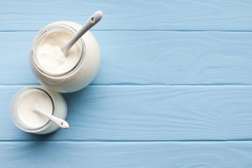 Wall Mural - Jars with milk on blue wooden background