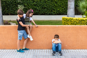 Wall Mural - Two children bullying another in the schoolyard