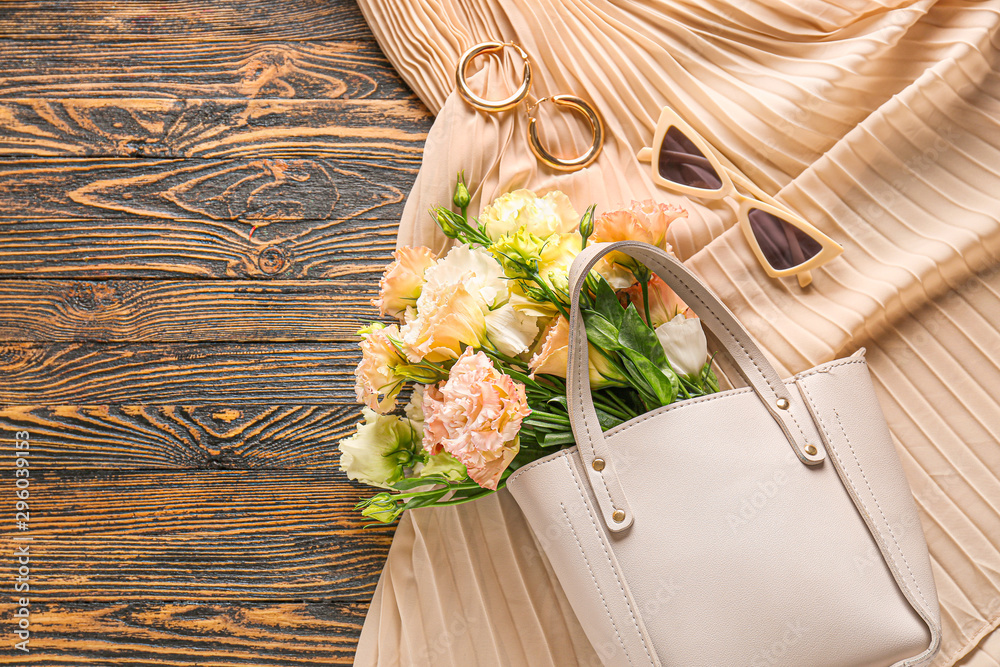 Eustoma flowers with female accessories on wooden background