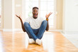 © Krakenimages.com - Handsome african american man sitting on the floor at home celebrating crazy and amazed for success with arms raised and open eyes screaming excited. Winner concept