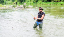 Fisher With Fishing Equipment. Fisher Weekend Activity. Fish On Hook. Leisure In Wild Nature. Fishing Masculine Hobby. Brutal Man Wear Rubber Boots Stand In River Water. Fun Of Fishing Is Catching