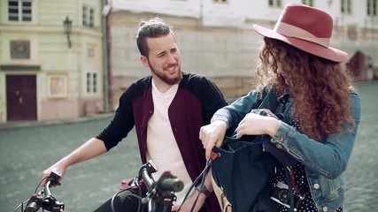 Wall Mural - young tourist couple travellers with map and scooters in small town.