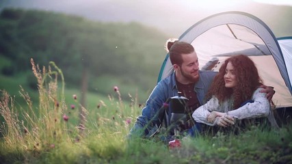 Wall Mural - young tourist couple travellers with tent shelter sitting in nature, resting.