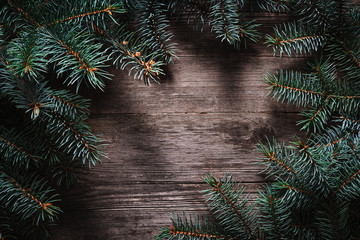 Wall Mural - Christmas green frame from fir branches on a vintage gray board background. Frame of fir branches. Christmas card blank.