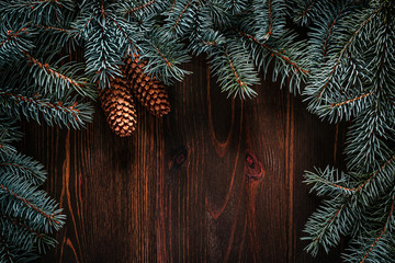 Wall Mural - Christmas green frame from fir branches on a vintage brown board background. Frame of fir branches. Christmas card blank.