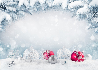 Merry Christmas card. Red christmas balls and baubles on the snow with fir branches.