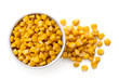 Canned sweet corn in a white ceramic bowl next to spilled sweet corn isolated on white. Top view.