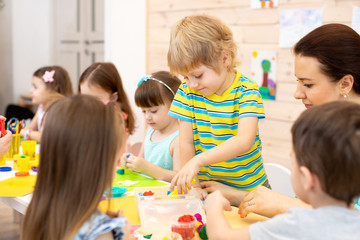 Wall Mural - Large group of preschool children with teacher on lesson class in kindergarten