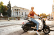 © Drobot Dean - Portrait of caucasian summer girl riding on scooter on city street